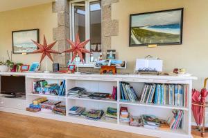 a white book shelf filled with books at La Demeure Océane in Portsall
