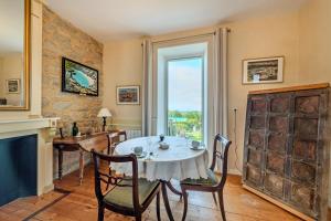 a dining room with a table and chairs and a window at La Demeure Océane in Portsall +13 photos