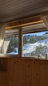 a window with a view of a snow covered field at Cosy Studio Mezzanine in Allevard