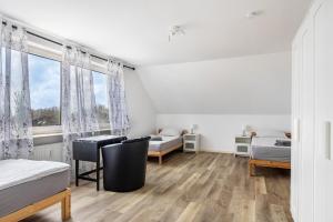 a bedroom with two beds and a desk and a window at Ferienwohnung Krautsand in Drochtersen