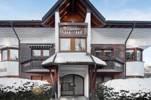 a house with snow on the front of it at Oskar im Bärenhüsli in Titisee-Neustadt