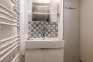 a bathroom with a white sink and a mirror at Cosy Studio Mezzanine in Allevard