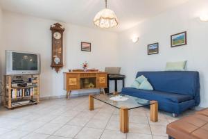 a living room with a blue couch and a tv at Baita Serpillo in Palù del Fersina