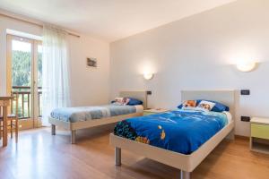 a bedroom with two beds and a window at Baita Serpillo in Palù del Fersina