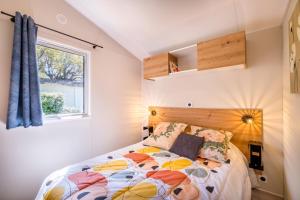 a bedroom with a bed and a window at Mobil-Home Baia in Saint-Raphaël +13 photos