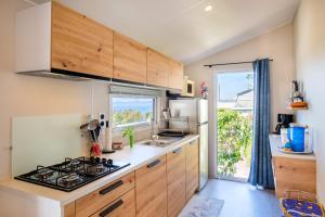 a kitchen with wooden cabinets and a stove top oven at Mobil-Home Baia in Saint-Raphaël