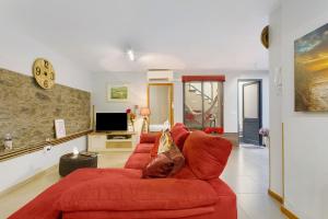 a living room with a red couch and a tv at Sissi Lanço Sea View 7 in Funchal