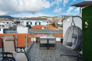 a patio with a table and chairs on a balcony at Sissi Lanço Sea View 7 in Funchal