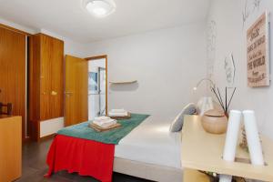 a bedroom with a bed with a table and a desk at Sissi Lanço Sea View 7 in Funchal