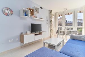 a living room with a blue couch and a tv at Recreo 10 in Torrox