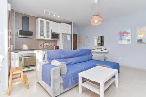 a living room with a blue couch and a kitchen at Recreo 10 in Torrox