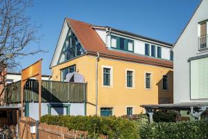 a yellow house with a wooden fence in front of it at Elbloft Radebeul Am Elberadweg Mit in Radebeul