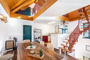 a kitchen and dining room with a wooden table and stairs at Elbloft Radebeul Am Elberadweg Mit in Radebeul