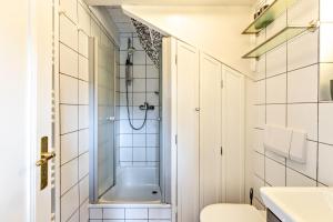 a small bathroom with a shower and a toilet at Skriiwers Hüüs in Alkersum +20 photos