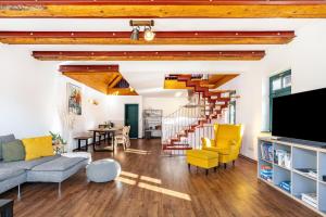 a living room with a staircase and yellow chairs at Elbloft Radebeul Am Elberadweg Mit in Radebeul