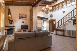 a large living room with a couch and a staircase at Es Caulls in Llubí