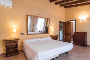 a bedroom with a large white bed and a mirror at Es Caulls in Llubí +27 photos