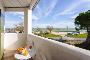 a balcony with a table and a view of the ocean at Les Pins, Rivedoux Beach House in Rivedoux-Plage