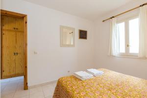 a bedroom with a bed with two towels on it at White Sands Maluz in Arenal d'en Castell