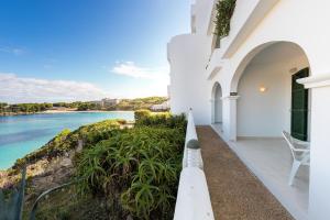a white house with a view of the ocean at White Sands Maluz in Arenal d'en Castell