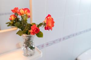a vase filled with red roses sitting on a table at White Sands Maluz in Arenal d'en Castell +17 photos