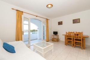 a living room with a couch and a table at White Sands Maluz in Arenal d'en Castell