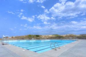a large swimming pool with a blue sky at 6165 - Fantasy Land in Kill Devil Hills