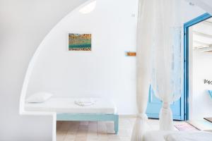 a white room with a bed and a window at Beachfront Lampis Dolphin 4 in Skala