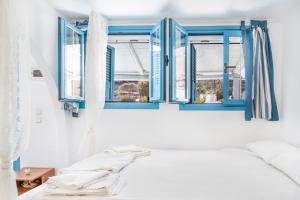 a bedroom with blue windows and a bed at Beachfront Lampis Dolphin 4 in Skala