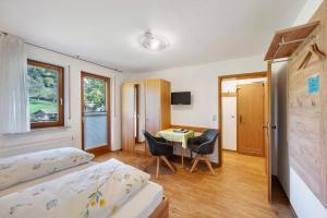 a bedroom with a bed and a table and chairs at Pension Schneider in Freiamt