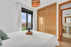 a bedroom with a white bed and a large window at Villa Manuela in Lajares