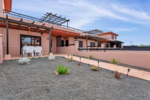 a house with a patio with a table and chairs at Villa Manuela in Lajares