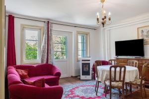 a living room with a pink couch and a tv at Villa Stanga in Sedico