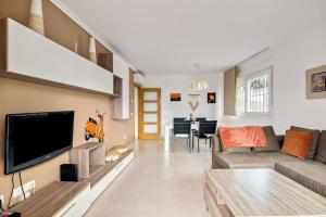 a living room with a couch and a tv on a wall at Amanda in Jávea