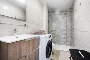 a white washing machine in a bathroom with a shower at Casa Jable in Costa de Antigua