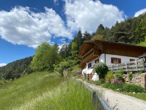 a house in the mountains with a grassy hill at Ferienhaus Leitner in Tires