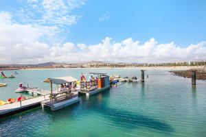 a dock with people on a boat in the water at Casa Jable in Costa de Antigua