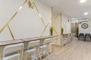 a room with tables and chairs and a clock on the wall at 7A Hostal in Torrevieja