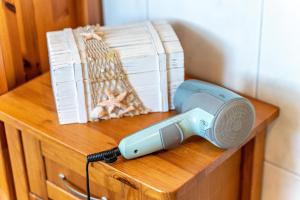a electric hairdryer on a wooden table with books at Wanglerhof Familie Wangler in Schuttertal