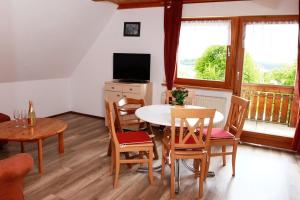 a living room with a table and chairs and a television at Bauernhof Mayer in Owingen