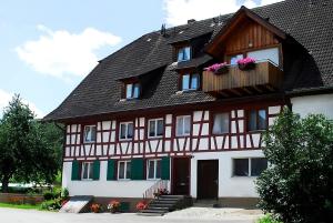 a house with a gambrel roof with flowers on it at Bauernhof Mayer in Owingen