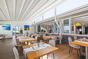 a restaurant with wooden tables and chairs and windows at Villa Ole Bahiazul-Private Jacuzzi in Corralejo