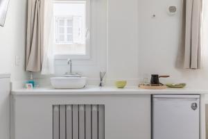 a kitchen counter with a sink and a window at A Tinian Room 1 in Tinos