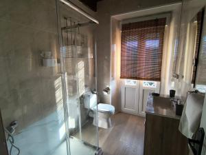 a bathroom with a toilet and a glass shower at Casa Adelina in Foz +20 photos