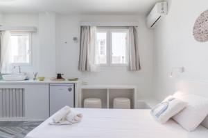 a white bedroom with a bed and a sink at A Tinian Room 1 in Tinos +16 photos