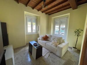 a living room with a white couch and a tv at Casa Adelina in Foz