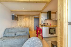 a living room with a couch and a kitchen at Appartement Alpe d'huez in LʼHuez