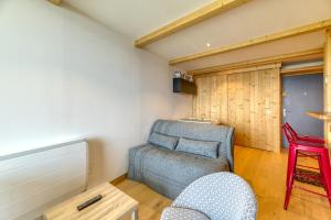 a living room with a chair and a table at Appartement Alpe d'huez in LʼHuez