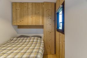 a small bedroom with a bed and a window at Appartement Alpe d'huez in LʼHuez