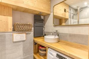 a bathroom with a sink and a washing machine at Appartement Alpe d'huez in LʼHuez +17 photos